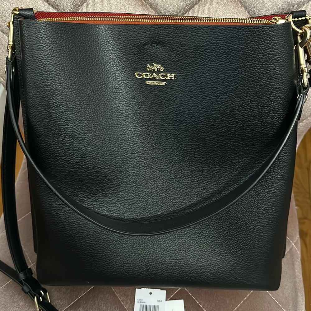 Coach Mollie Bucket Bag in black with red interior.